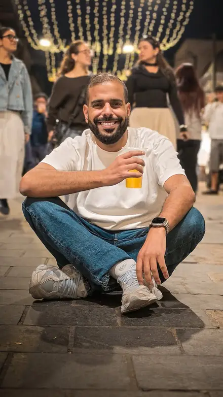 נריה אנג'ל יושב ומחייך בשוק מחנה יהודה בערב