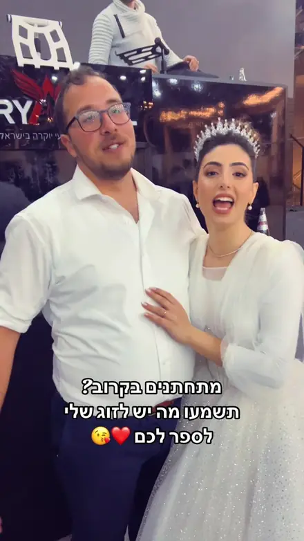 חתן וכלה ליד עמדת הדי ג'יי ממליצים על נריה אנג'ל