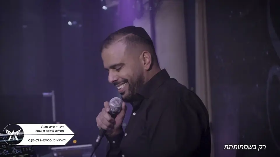 נריה אנג'ל שר במיקרופון ומחייך